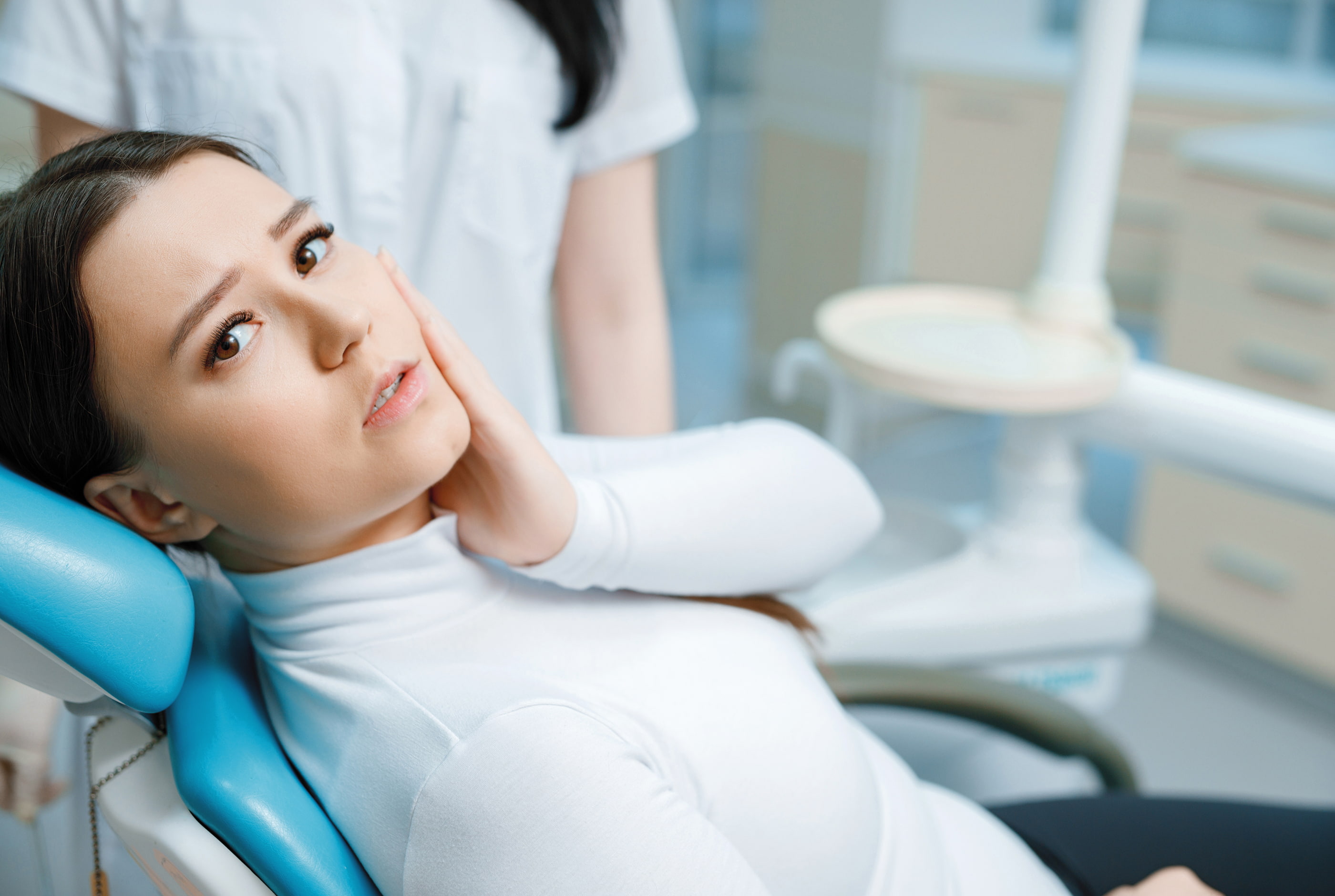 Friendly dental team assisting patient with scheduling and insurance questions
